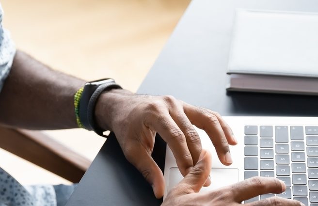 Hands typing on a laptop keyboard