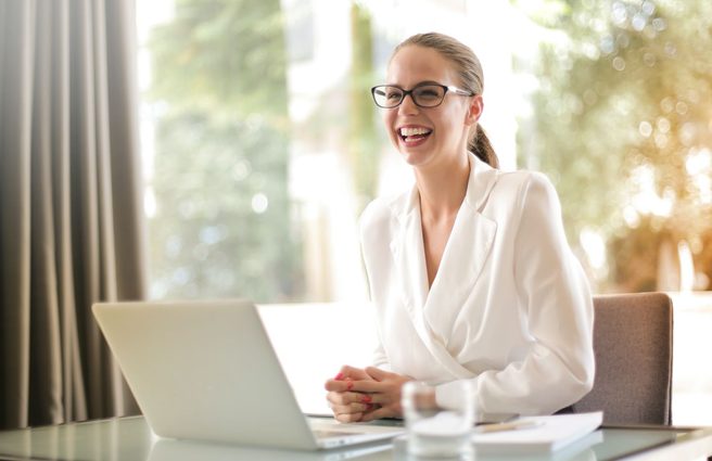 Person smiling at a laptop