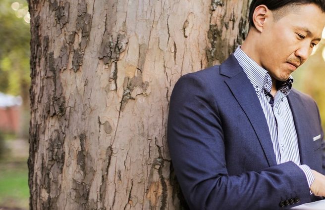 Man in suit on laptop outdoors