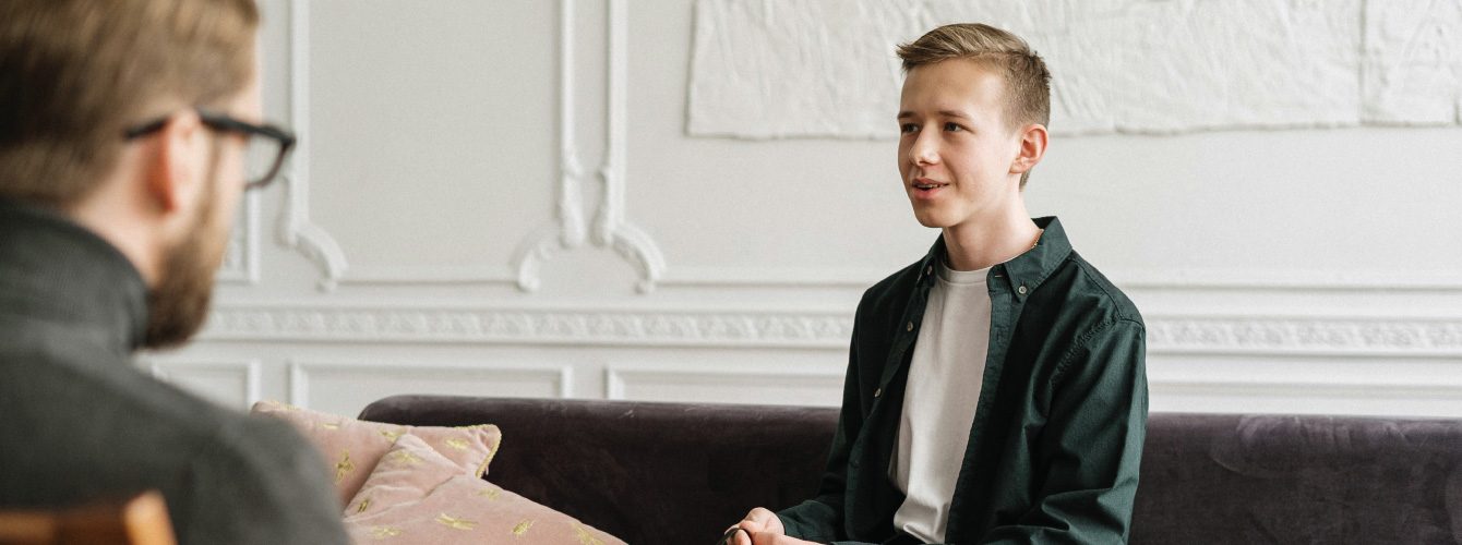 Young man smiling talking to psychology professional