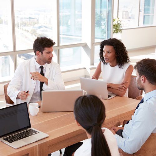healthcare professionals sitting on table, talking